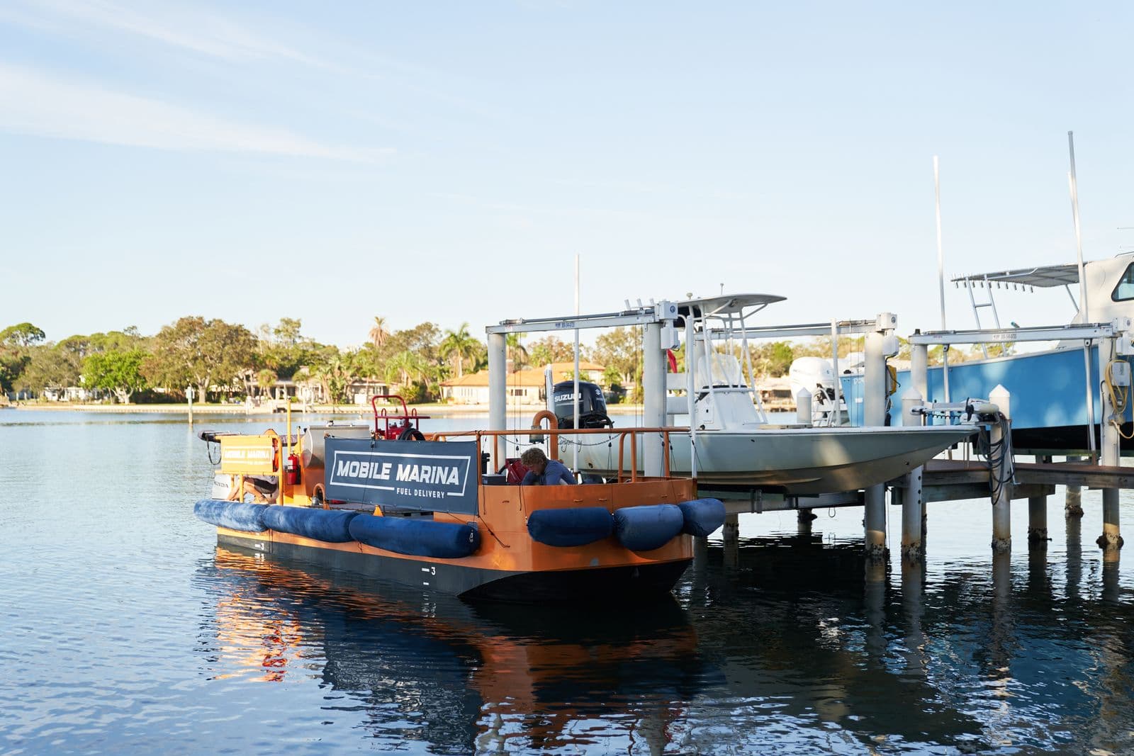 Mobile Marina water-based fuel delivery vessel beside boats on lifts in Tampa Bay