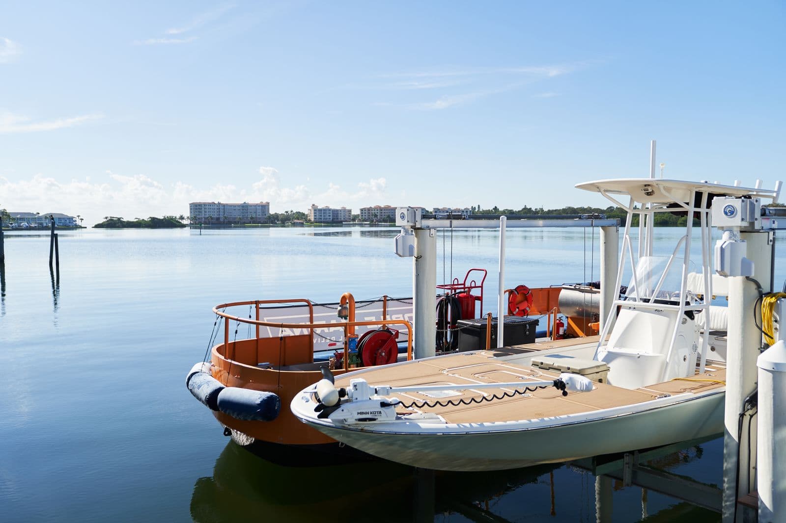 Mobile Marina fuel vessel with hose reel docked beside a center console