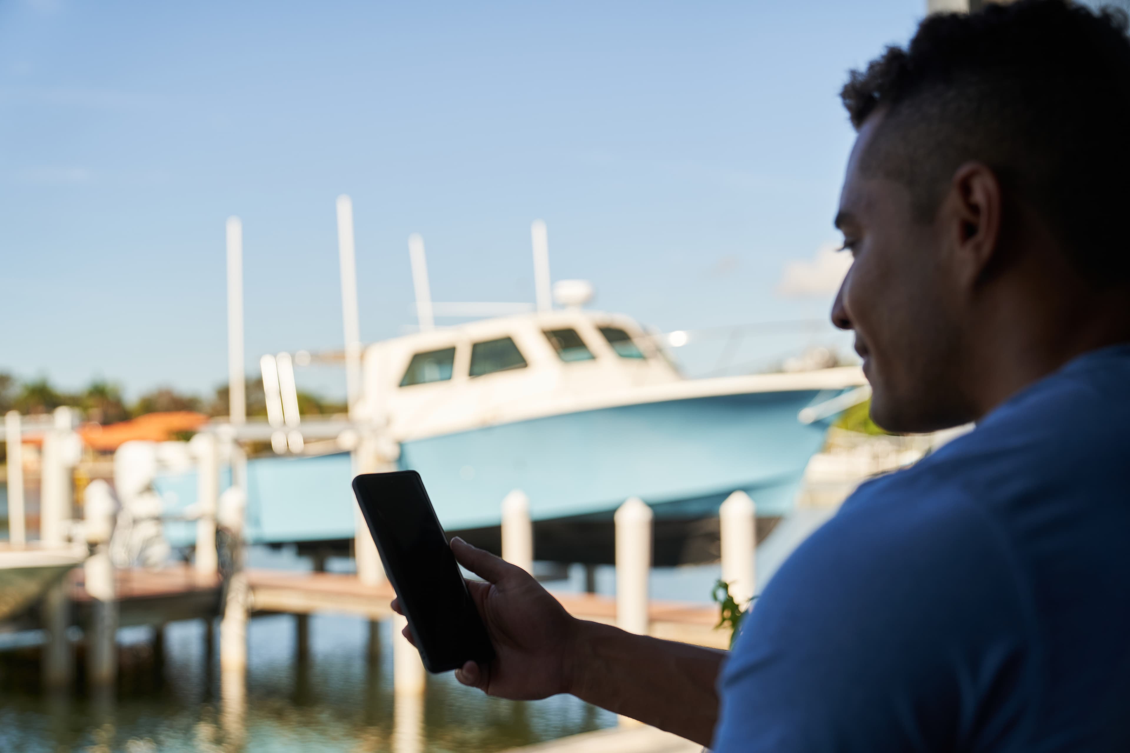 Boat owner managing their vessel from their phone at the dock