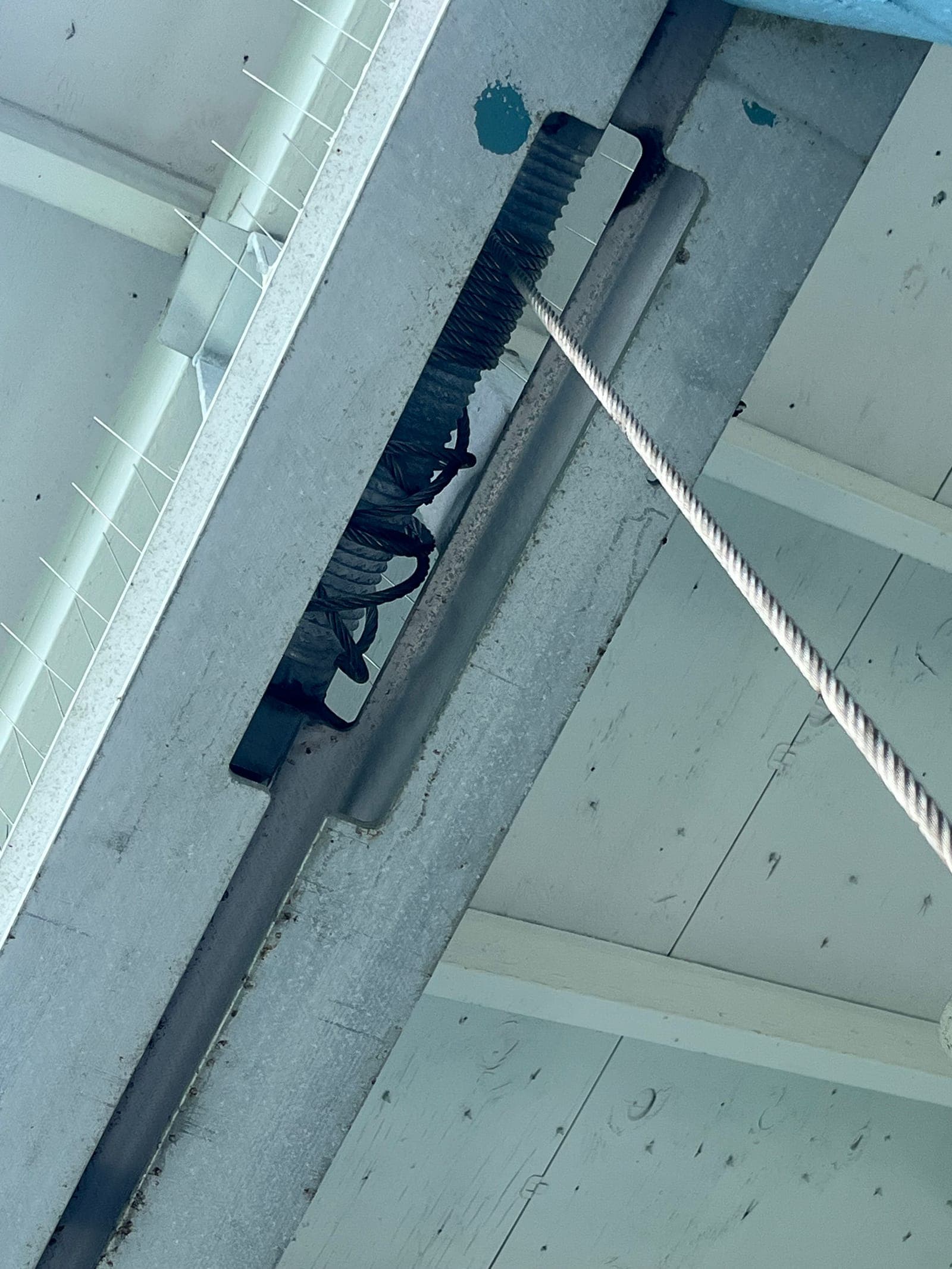Close-up of wire rope routed through a repaired cable-wrap assembly on a personal watercraft lift