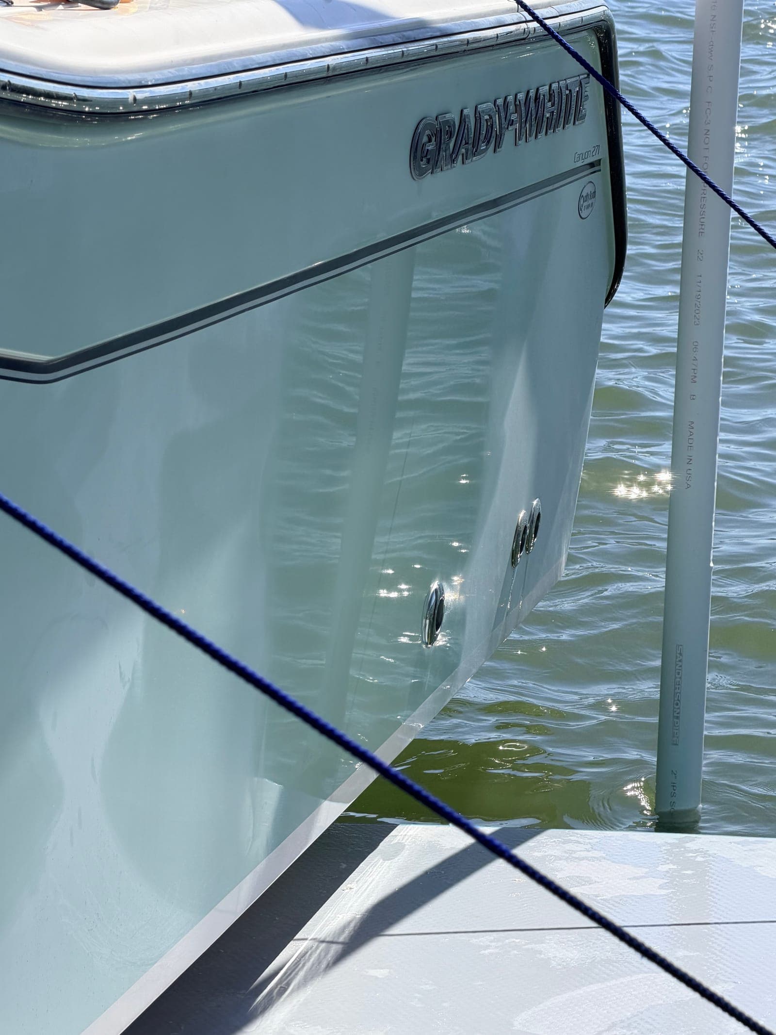 Grady-White hull side after a fresh wax cycle — the mirror finish a regular 8-week schedule preserves on Tampa Bay gelcoat