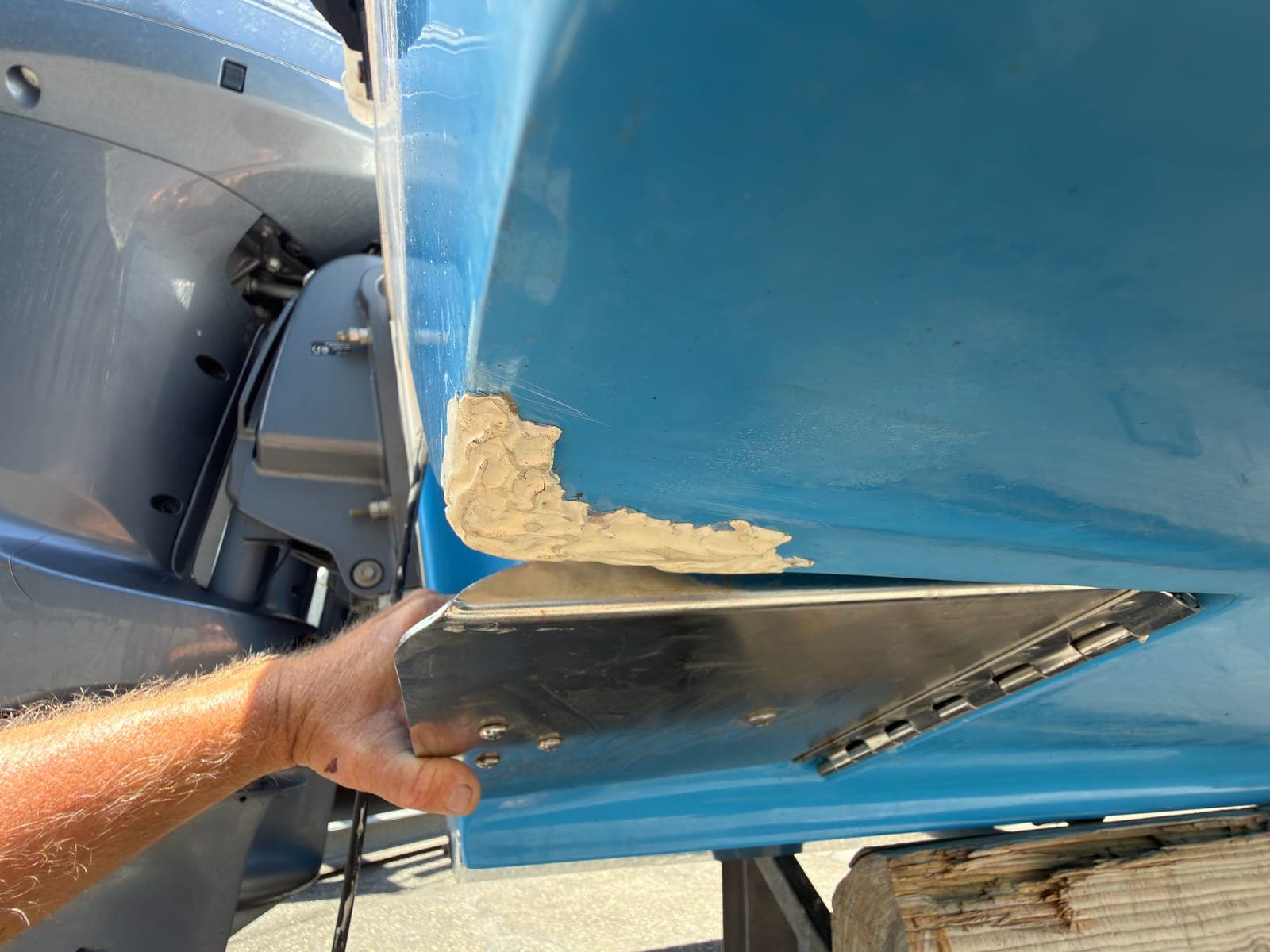 Damaged hull area beside stern hardware that requires controlled shop access for a proper repair