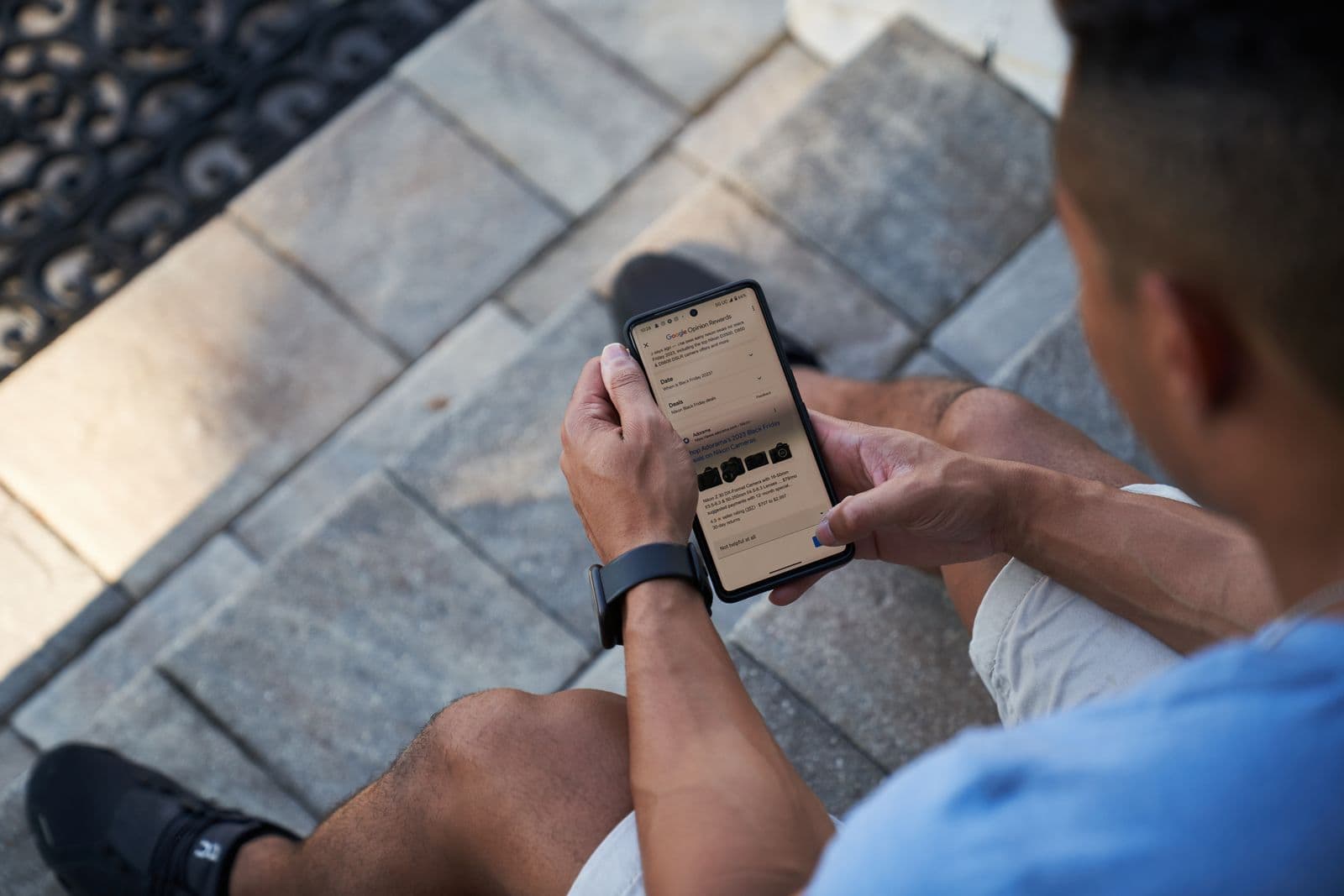 Person sitting on patio steps holding a phone with a form on the screen