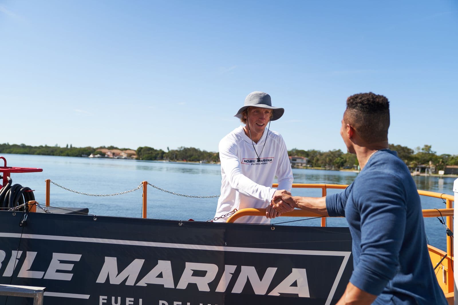 Mobile Marina captain greeting a boat owner at a residential dock after a scheduled fuel delivery